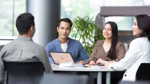 students working at a table with laptop