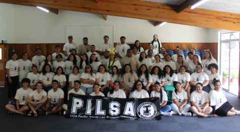 A large group of people holding a banner that reads: PILSA.