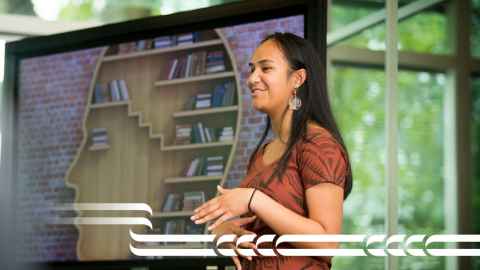 Photo of student presenting at front of room 