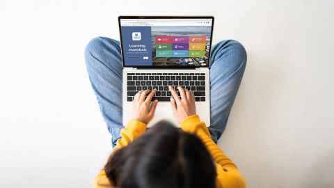 A photo of a student using their laptop on the Learning Essentials landing page. 