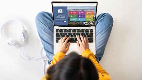 Girl using laptop with Learning Essentials homepage on screen