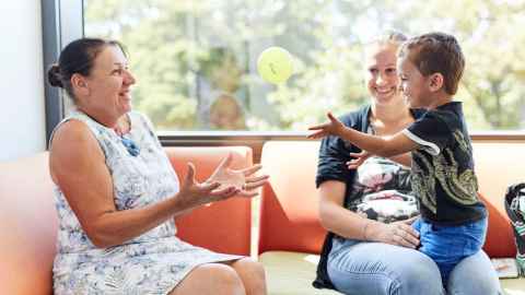 Liggins Institute staff member with mother and child in the Clinical Research Unit