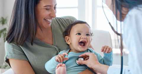 Mother with baby being examined by doctor