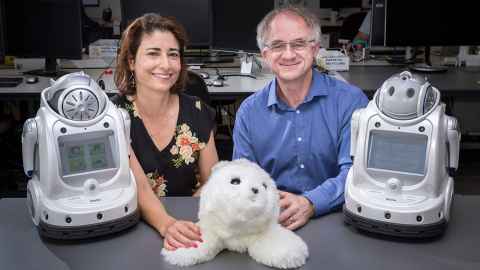 Elizabeth Broadbent and Bruce MacDonald with three robots