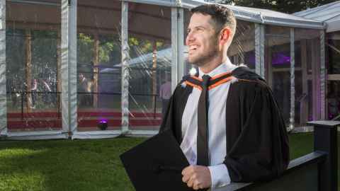 Oliver Scott-Mackie wearing academic regalia