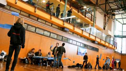 Students holding paper gliders inside the Recreation Centre.