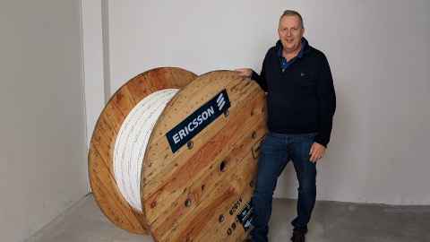 FiComms CEO and Founder Sean Rainthorpe alongside a wheel of fibre optic cabling.