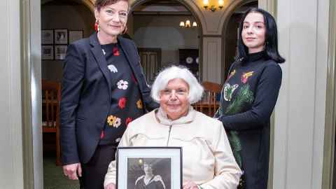 Dame Charmian O'Connor (seated) with her daughter Kate (left) and her granddaughter Indigo. She is holding a photo of her mother.