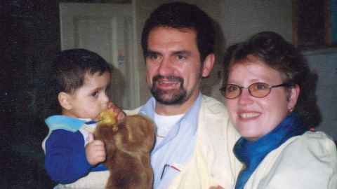 Alex Kuch, aged 18 months, with his adoptive parents.