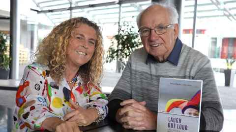 Barbara Plester and Kerr Inkson with a copy of the book "Laugh Out Loud"