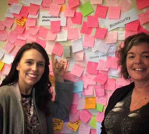 Professor Juliet Gerrard (right) with Prime Minister Jacinda Ardern in front of the wall of 'sticky' issues from New Zealand's research community.
