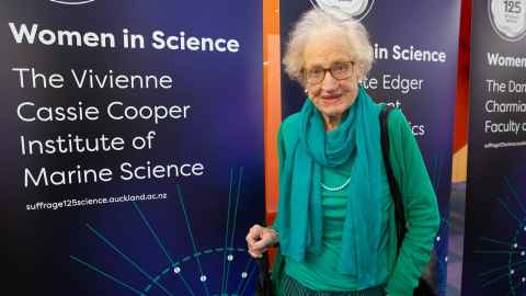 Vivienne Cassie Cooper with the banner naming The Vivienne Cassie Cooper Institute of Marine Science.