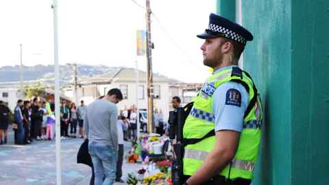 A heavily armed police officer guards the Kilbirnie Mosque the day after the Christchurch terrorist attack. Photo: Lynn Grieveson