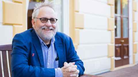 Professor Peter Adams seated outside Old Government House