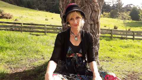Harley Hern sitting in a field under a tree