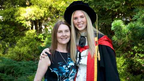 Dr Laura Chubb, wearing academic regalia and with her arm around her mother, Theresa.