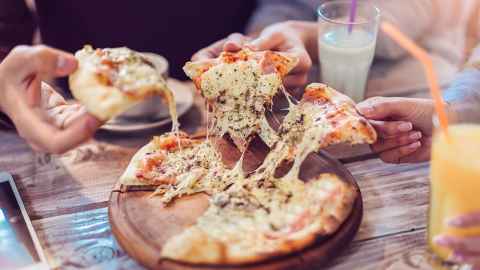 Several people sharing a pizza