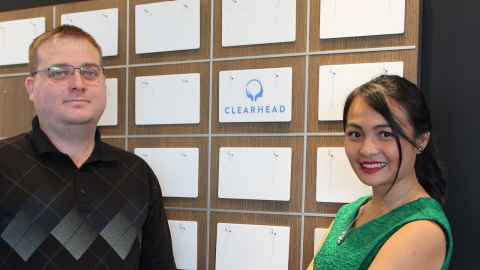 Michael Connolly and Angela Lim standing next to a wall with the Clearhead logo.
