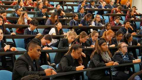 A lecture theatre full of students taking notes