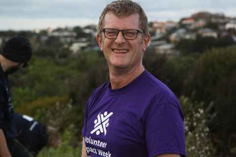 Mark Bentley wearing a purple Volunteer Impact Week T-shirt