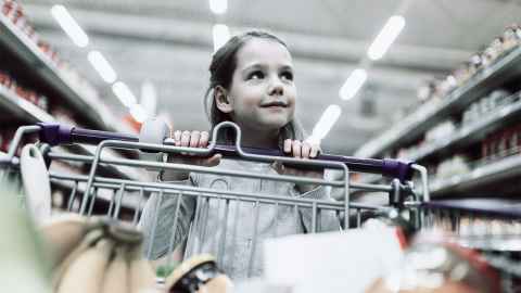 Child pushing a trolley in a supermarket.