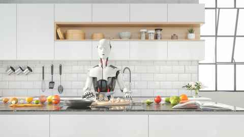 A robot is pictued preparing food at the counter of a smart contemporary kitchen: Robots taking over our domestic chores? Alas, they’ve barely made it through our front doors says Craig Sutherland.