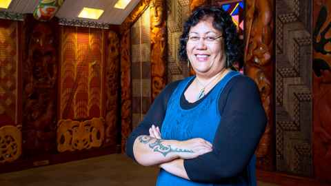 Dr Aroha Harris standing inside a marae building