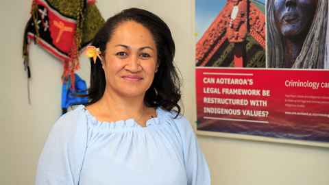 Dr Tamasailau Suaalii-Sauni standing next to a poster with the text "Can Aotearoa's legal framework be restructured with indigenous values?"