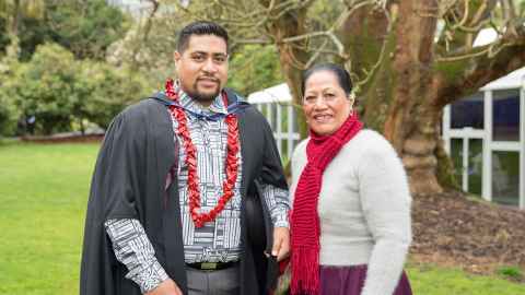 Kent Onesemo, wearing academic regalia and a red ula fala necklace, and his mother Poutasi Onesemo.