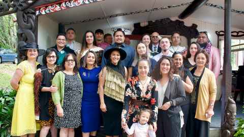 A group of 24 students gathered outside a wharenui.