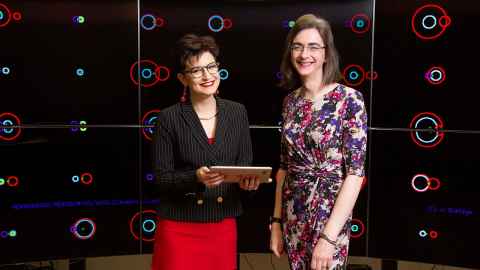 Dr Héloïse Stevance (left) and Dr JJ Eldridge in the Centre for eResearch Visualisation Suite in front of representations of binary stars.