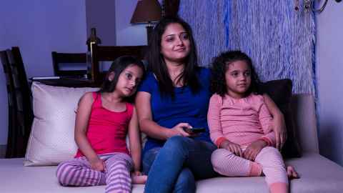 A mother sits with her daughters watching TV: Migrants told researchers their view of Māori changed positively having watched Māori TV. Photo: iStock sit together to watch TV