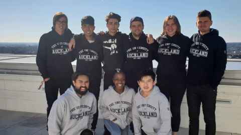 Nine students wearing University of Auckland sweatshirts