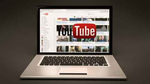 A laptop open with YouTube on the screen