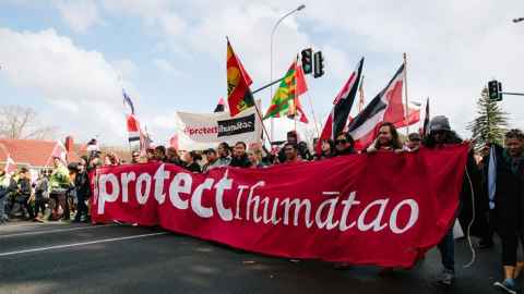 Protestors blocking the road with a banner declaring "Protect Ihumātao" are pictured in an image from last year when the site was capturing headlines. But work has continued behind the scenes explains Dr Hancock. Photo: Emily Parr (Accompany Collective)from last year when Ihumātao was capturing headlines, but work has continued behind the scenes explains Dr Hancock. Photo: Emily Parr (Accompany Collective)