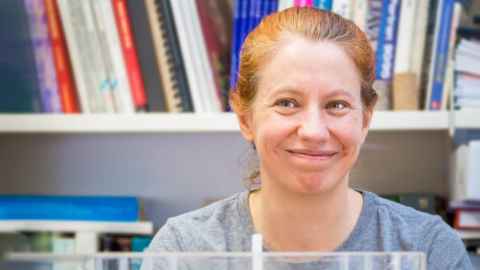 Professor Rosalind Archer with bookshelves in the background