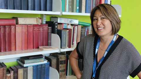Stephanie Yee standing next to some bookshelves
