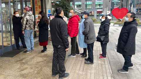 Shoppers wearing face masks are pictured lining up for temperature checks before entering a shopping mall in Chengdu, China. Photo: iStock 