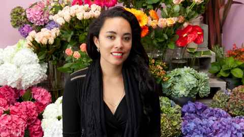 Courtney Sina Meredith standing in front of plants and flowers