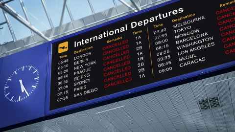 An airport departure board showing that all flights have been cancelled