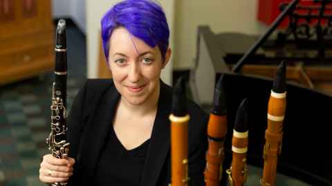 Dr Marie Ross, with a modern clarinet and some of her old ones. 