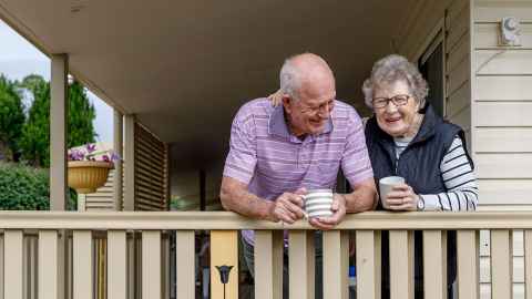 The image shows an older couple on the deck of a house: Friends living together are worse off than friends together in a relationship, but this must change. Photo: iStock