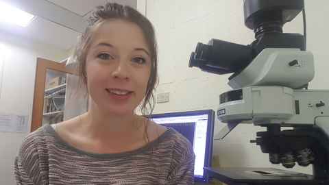 Amy Martin next to a computer and microscope
