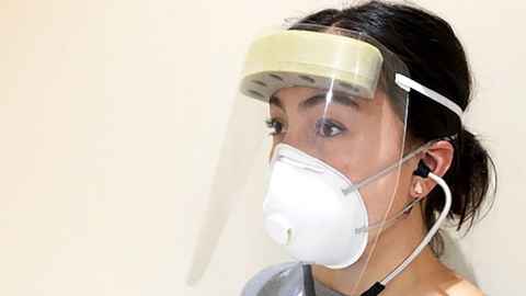 Person wearing a laser cut disposable face shield