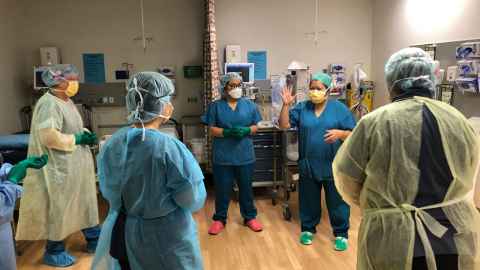 A group of healthcare workers wearing and scrubs, PPE and masks.