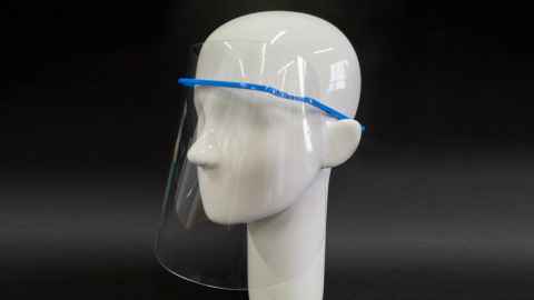 A clear plastic face shield with a blue frame fitting over the ears