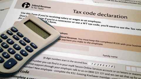 A calculator sitting on a tax code declaration form.