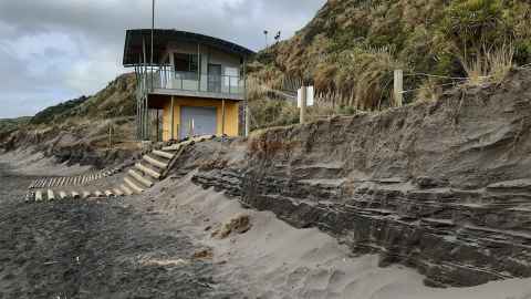 A beach with a wall of eroding earth.
