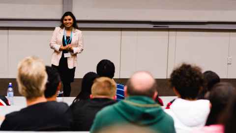 A woman standing in front of a group of people.