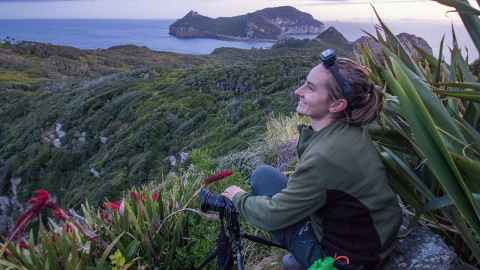 PhD candidate Edin Whitehead in the wilderness, with a camera.